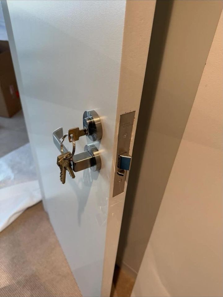 Two deadlocks with keys fitted to a white door