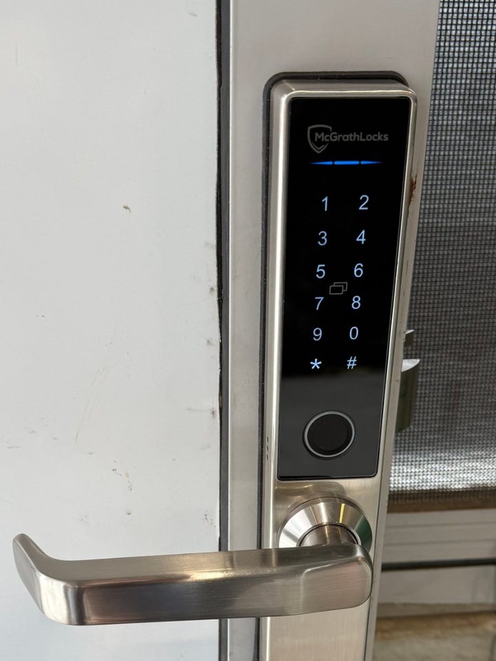 Keypad and fingerprint smart lock with lever handle on an aluminium door