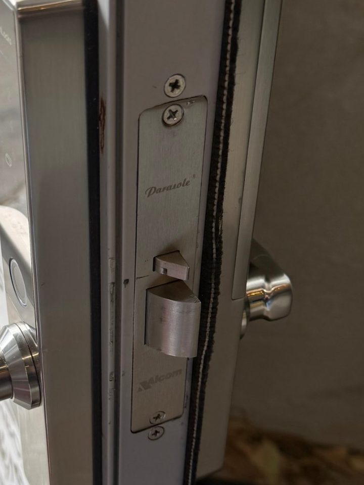 Edge of an aluminium door showing a newly fitted smart lock mortice and latch